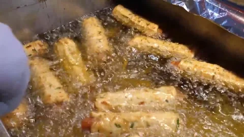 Deep-frying Korean fish cakes (Eomuk) in hot oil, traditional street food prepar Stock Footage 337374476