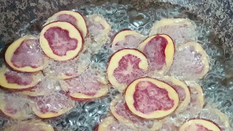 Deep frying native Peruvian purple potato slices. Stock Footage 339078246