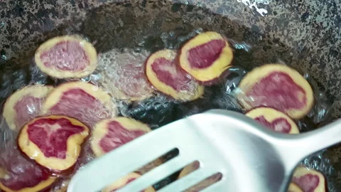 Deep frying native Peruvian purple potato slices. Video stock 339078291