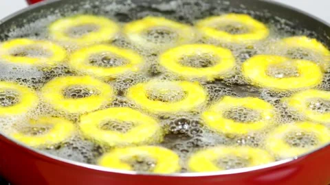 Deep frying onion rings in a red skillet in the kitchen Stock Footage 256039281