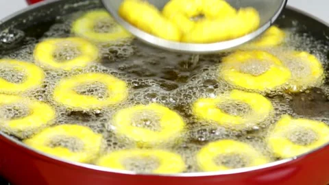 Deep frying onion rings in a red skillet in the kitchen Stock Footage 256039286