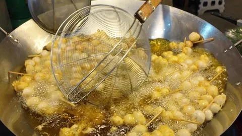 Deep Frying Skewered Snack Balls in Bubbling Oil Using Wire Skimmer Video stock 330157238