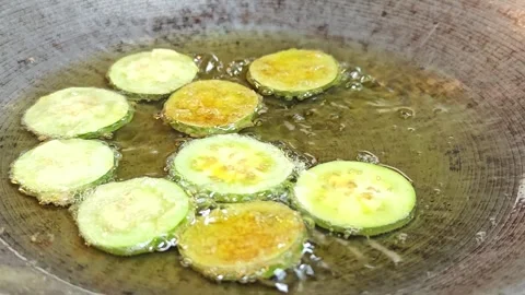 Deep frying sliced eggplants with egg in a traditional wok. Stock Footage 342394998