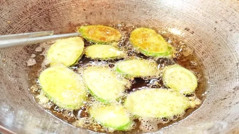 Deep frying sliced eggplants with egg batter in a wok. Stock Footage 342400959
