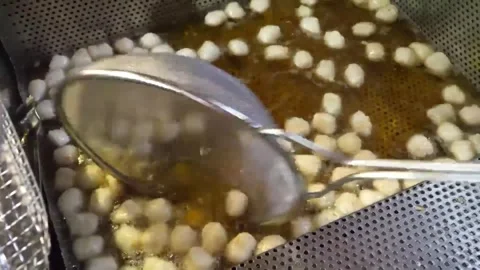 Deep frying small Korean fish cakes in hot oil Stock Footage 337374804