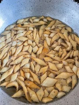 Deep frying a tea time snack made with whole wheat flour called Nimki in pi.. Stockfoto's