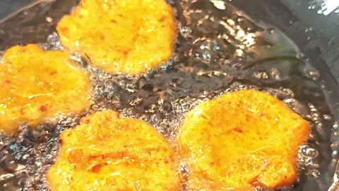 Deep frying traditional Thai fish cakes in hot cooking oil. Vídeo Stock 342394562