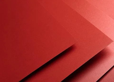 Deep garnet red paper background with a glossy, reflective texture and stacke Stock Photos