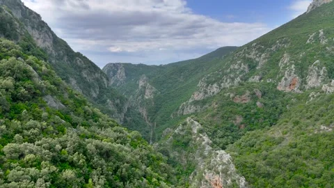 Deep Green Mountain Gorge Toward Distant Sea in Greece Stock Footage 336564920