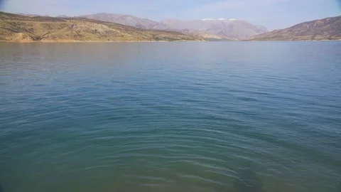 A deep mountain lake surrounded by rocks on a cloudy day Stock Footage 246900086