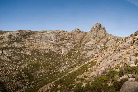 Deep mountain valley surrounded by peaky mountains Stockfoto's