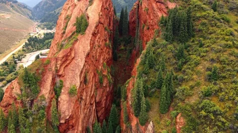 Deep narrow chasm between Seven Bulls red rock pillars in Kyrgyzstan Stock Footage 344410111