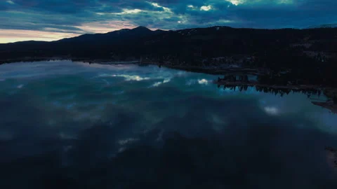 Deep night over Big Bear Lake with dark mountains and faint reflections 库存影片 328898245