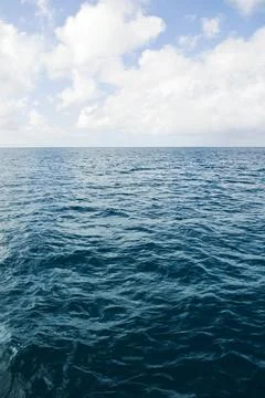 Deep ocean view with waves and white clouds. Endless tropical sea background. Stock Photos