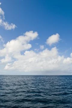 Deep ocean view with waves and white clouds. Endless tropical sea background. Stock Photos