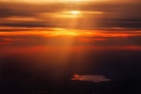 Deep Orange Red Sunset Coming Through Clouds on Dark Landscape Pond Water Stock Photos