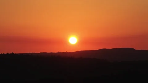 Deep Orange Sun Above Dark Forest Hills at Dusk Stock Footage 340572755