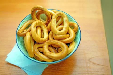 Deep plate filled with medium-sized fresh bagels, showcasing their golden-bro Stock Photos