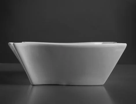 Deep porcelain dish on gray table. White bowl front view Stock-Fotos
