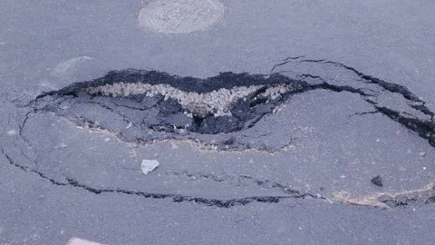Deep Pothole and Cracked Asphalt Damage on City Road Stock Footage 345211570