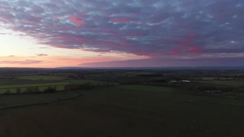 Deep purple cloudy sunset over english countryside from aerial drone view Stock Footage 221218159