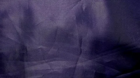 Deep purple fabric texture undulating softly in shadowy folds evoking luxurious Stock Photos