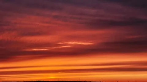 Deep red and orange sunset sky with soft cloud layers Stock Photos