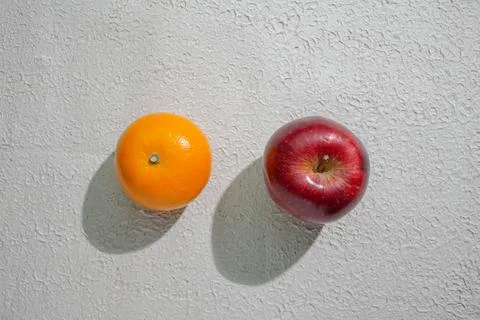 A deep red apple and orange isolated on a clean white background, symbolizi.. Stock Photos
