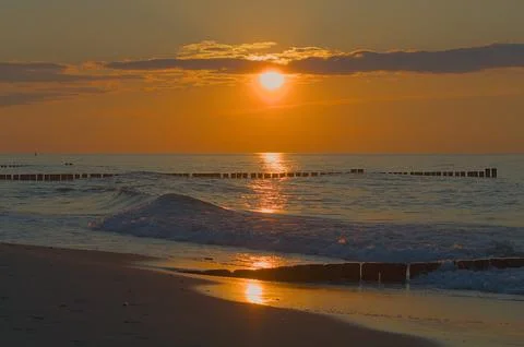 A deep red-orange sunset over the calm Baltic Sea. Stock Photos