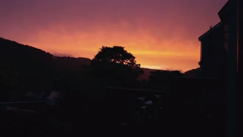 Deep red sky Timelapse of clouds passing in dark silhouette of welsh valley Stock Footage 198896177