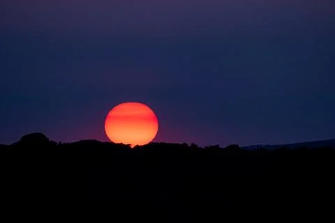 Deep red sun setting over Seaford in Sussex. Stock Photos