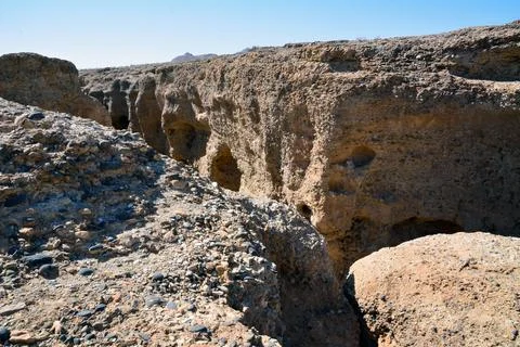 A deep rocky canyon with a shell in the bright sun under a blue sky Stock Photos