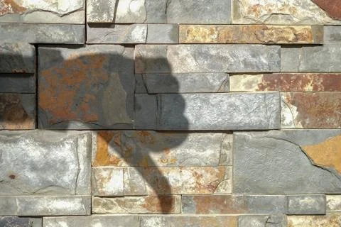Deep shadow of dislike on decorative wall of stone Stock Photos