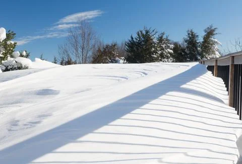 Deep snow in drifts on deck in back yard Stock Photos