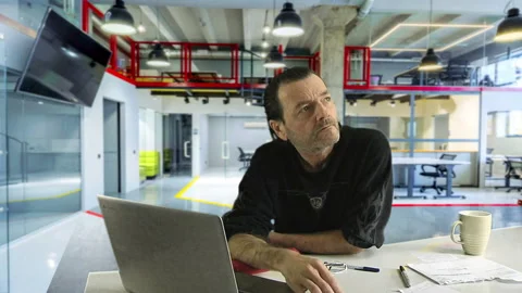 Deep in Thought: Man in Black Shirt Reflecting in Office Stock Footage 237640586
