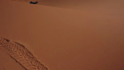 Deep tire tracks crossing orange Sahara sand dune in Merzouga Morocco Stock Footage 334512147