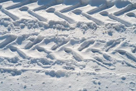 Deep tread marks of car wheels on loose snow, winter snowy background Stock Photos