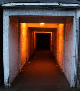 Deep tunnel with viewpoint on other side  with yellow light Dark tunnel in urban Stock Photos