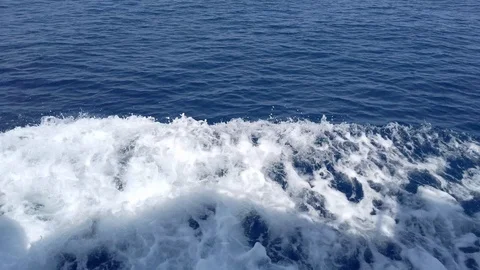 Deep turquoise and blue Mediterranean sea with white foam from boat Stock Footage 123769370