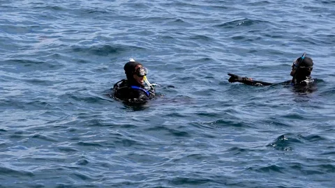 Deep water scuba divers floating in ocean and talking Stock Footage 106480935