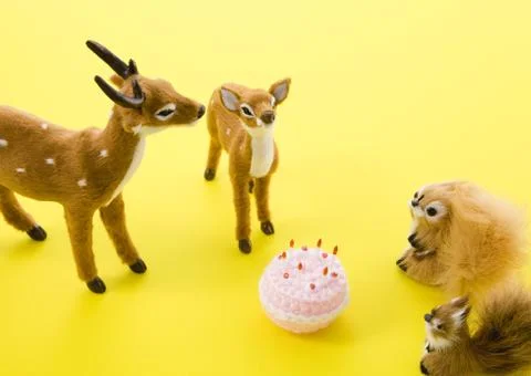 Deer and squirrel figurines and cake Stock Photos