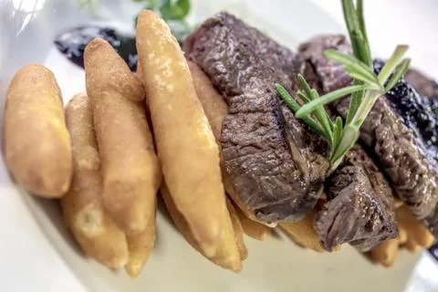 Deer backstrap on pine needles, honey onion and potato puree Stock Photos
