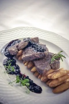 Deer backstrap on pine needles, honey onion and potato puree Stock Photos