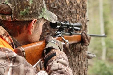 Deer hunter aiming rifle close-up Stock Photos