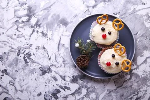 Deer shaped cupcake on gray background with place for text. Decor for Christm Stock Photos
