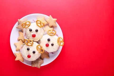 Deer shaped cupcake on a red background with place for text. Decor for Christ Stock Photos