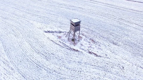 Deer-stand or watch tower for hunting of boars in snowy fields. Video stock 101071990