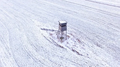 Deer-stand or watch tower for hunting of boars in snowy fields. Video stock 101072256