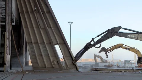 Deere 670G Excavator pulls large hangar door 2 Video stock 109355676