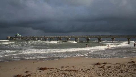 Deerfield Beach, Florida Pier Cloudy Evening Rough Seas People Swimming Stock Footage 76779434
